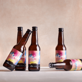 botellas de cerveza Ètika colocadas de forma divertida: 3 de pie, 1 inclinada y otra tumbada en el suelo